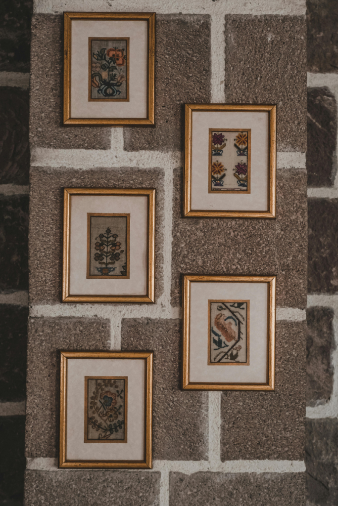 Upcycled heritage saree fabric framed as a textured statement piece on a living room wall.