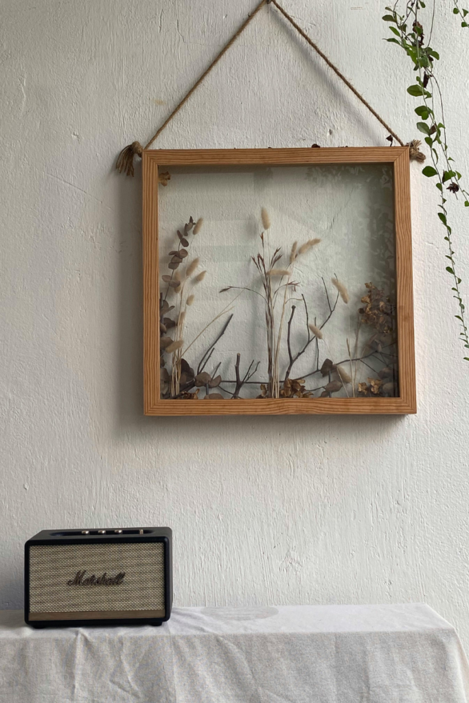 DIY botanical wall art featuring pressed flowers in a glass floating frame.